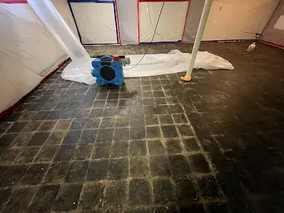 Basement under plastic containment with an air mover running in St. Charles County