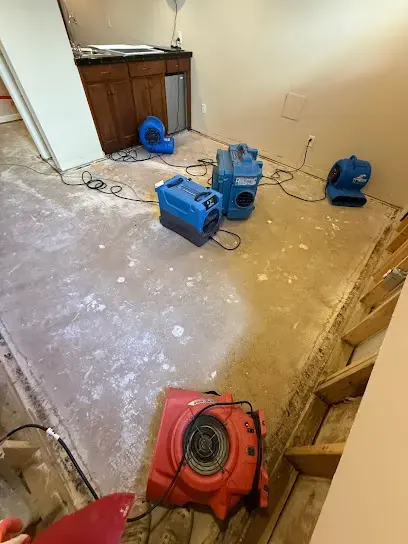 Air movers drying a stripped floor during an O'Fallon water damage dry-out