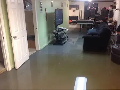 Standing water across a finished basement rec room in St. Charles County